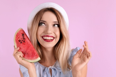 Pretty young woman with juicy watermelon on color background