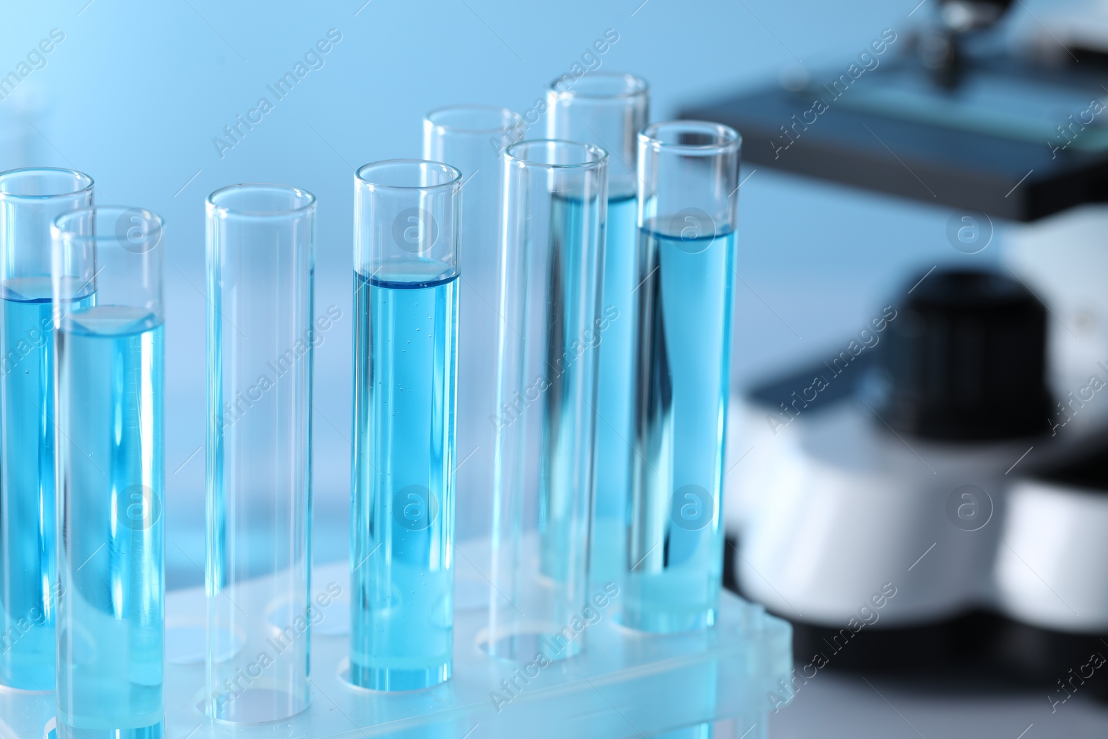 Photo of Test tubes with light blue liquid in laboratory, closeup