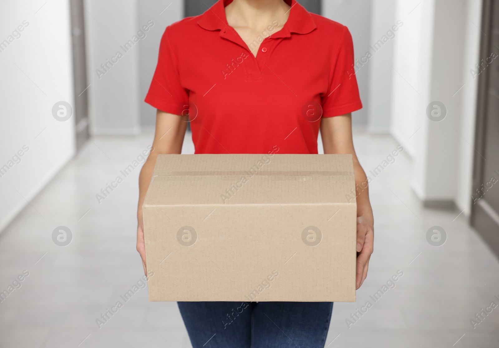 Photo of Courier with cardboard boxes in hallway, closeup