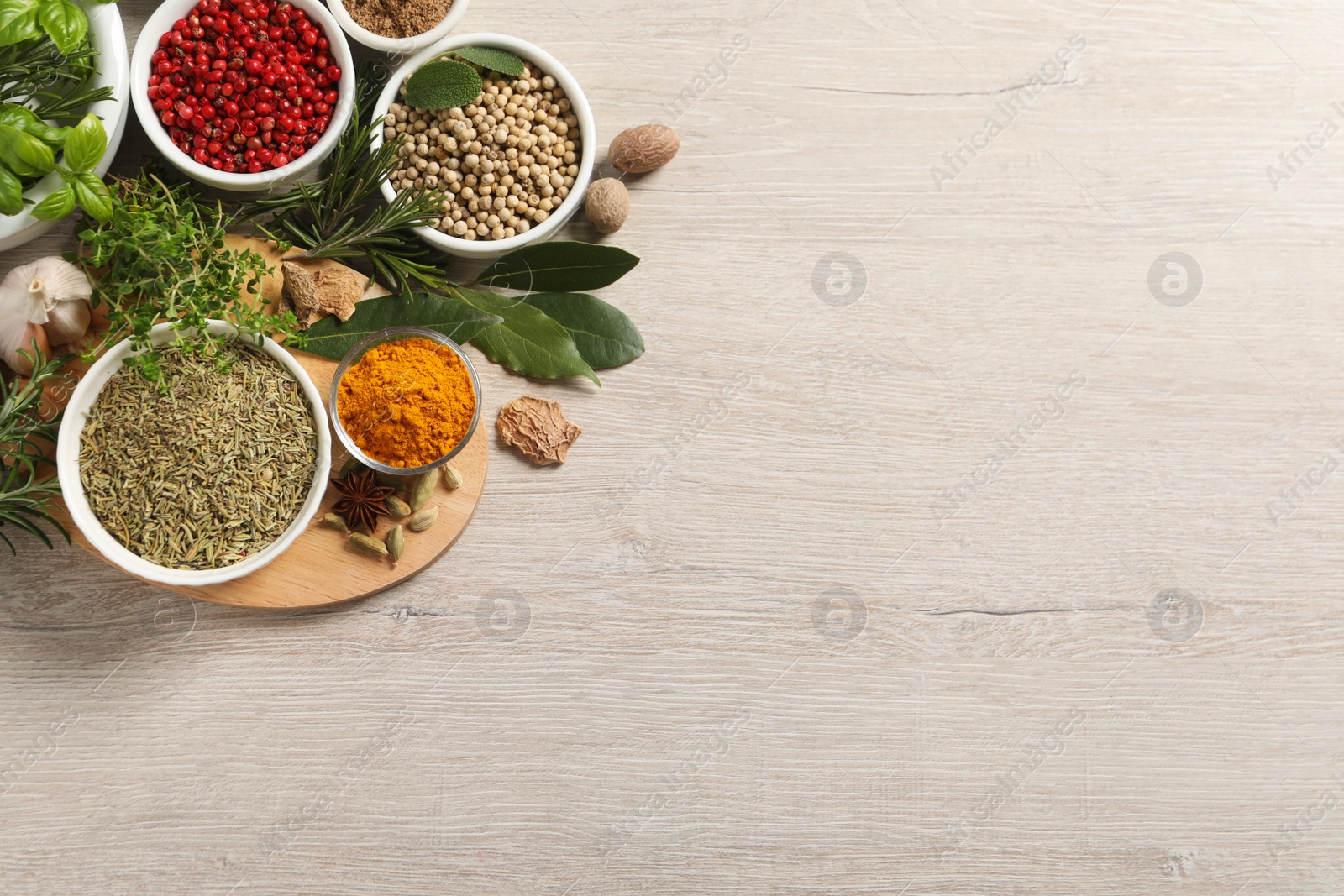 Photo of Different herbs and spices on wooden table, flat lay. Space for text