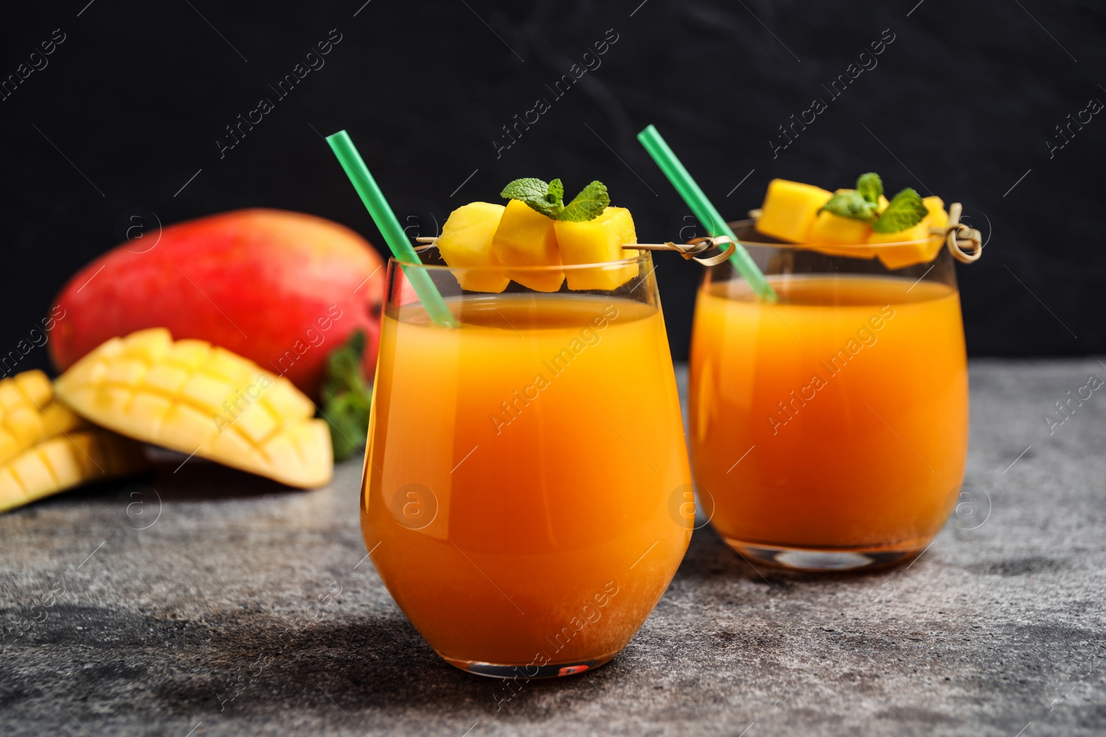 Photo of Fresh delicious mango drink on grey table