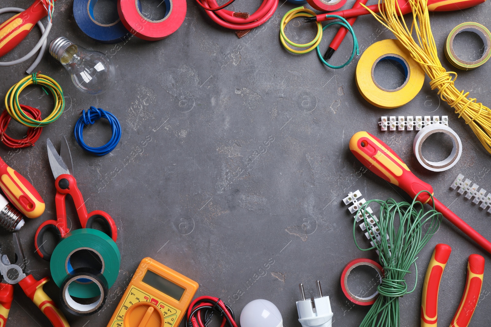 Photo of Frame of electrician's tools and accessories on grey background, flat lay. Space for text