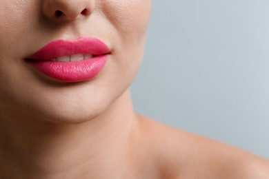 Photo of Closeup view of woman with beautiful lips on light grey background. Space for text