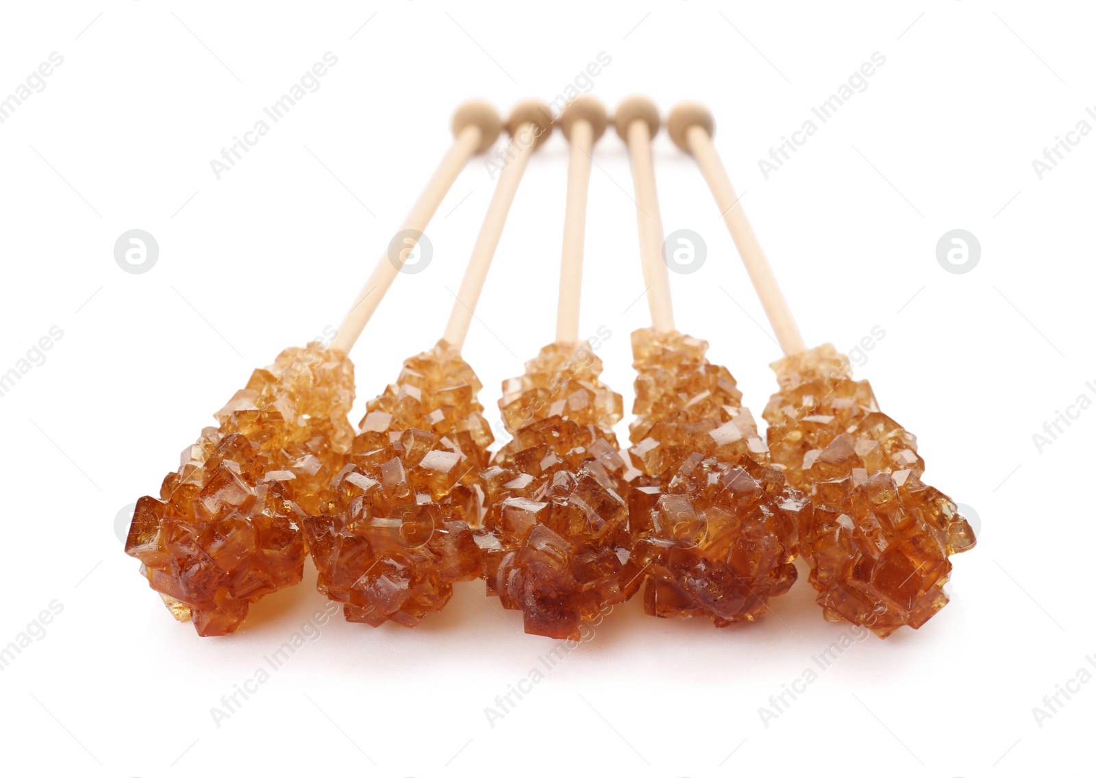 Photo of Wooden sticks with sugar crystals isolated on white. Tasty rock candies