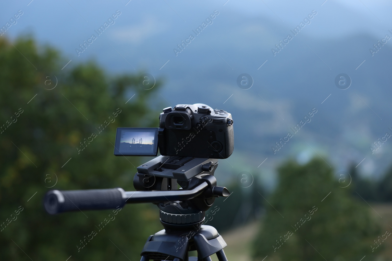 Photo of Taking photo of beautiful landscape with camera mounted on tripod outdoors