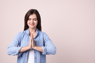 Photo of Young woman meditating on light background, space for text. Stress relief exercise