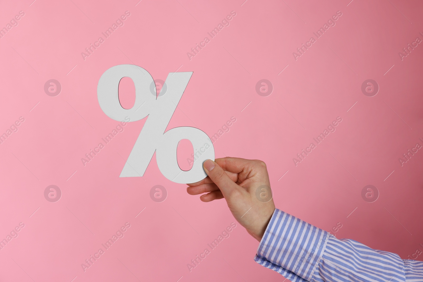 Photo of Woman holding percent sign on pink background, closeup