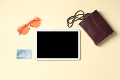 Photo of Online store. Tablet, sunglasses, bag and credit card on beige background, flat lay