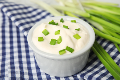 Fresh sour cream with onion on fabric, closeup