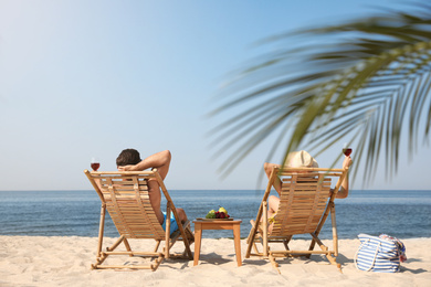 Photo of Couple with wine on sunny beach at resort