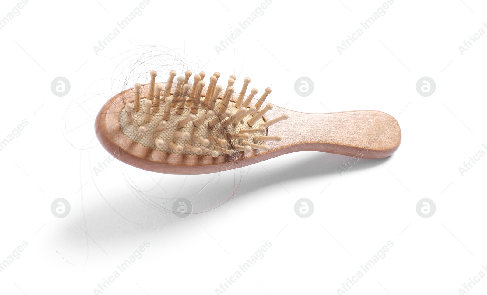 Photo of Brush with lost hair in air on white background