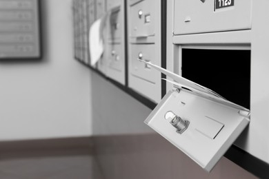 Photo of Open metal mailbox with envelopes indoors, closeup view