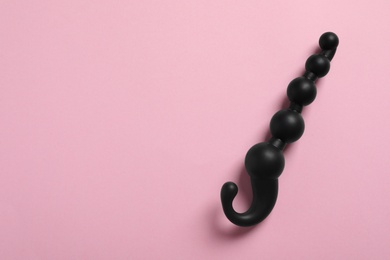 Black anal ball beads on pink background, top view with space for text. Sex toy