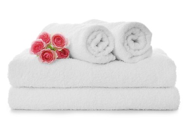 Photo of Fresh clean towels with roses on white background