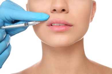 Photo of Young woman getting facial injection on white background, closeup. Cosmetic surgery concept