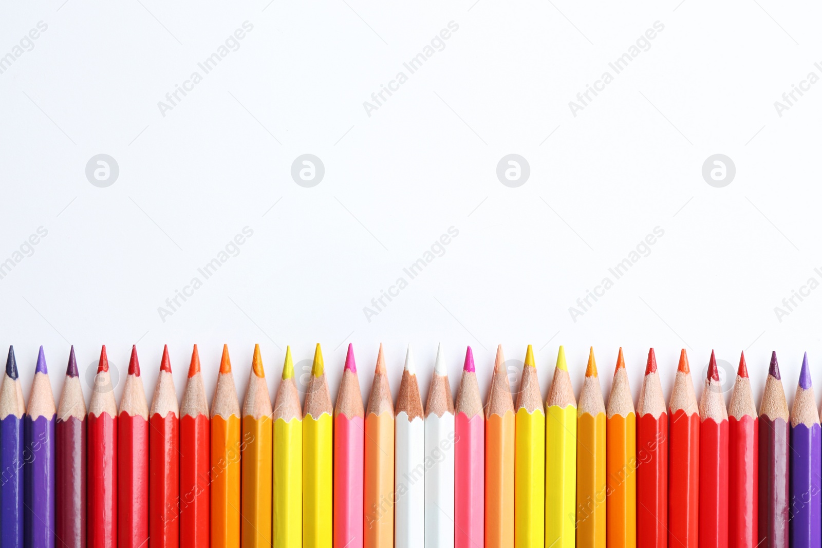 Photo of Composition with color pencils on white background, flat lay. Space for text