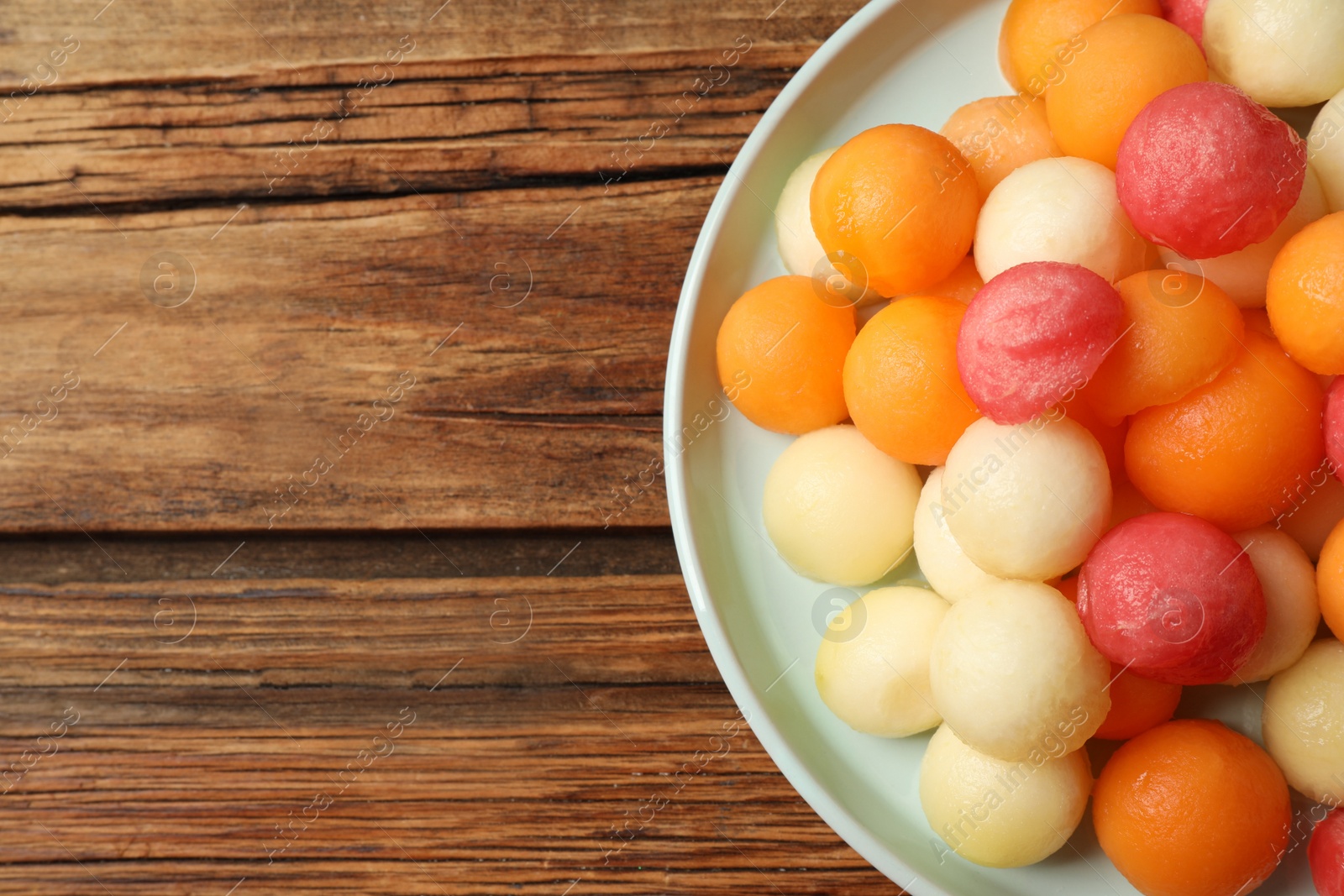 Photo of Melon and watermelon balls on wooden table, top view. Space for text