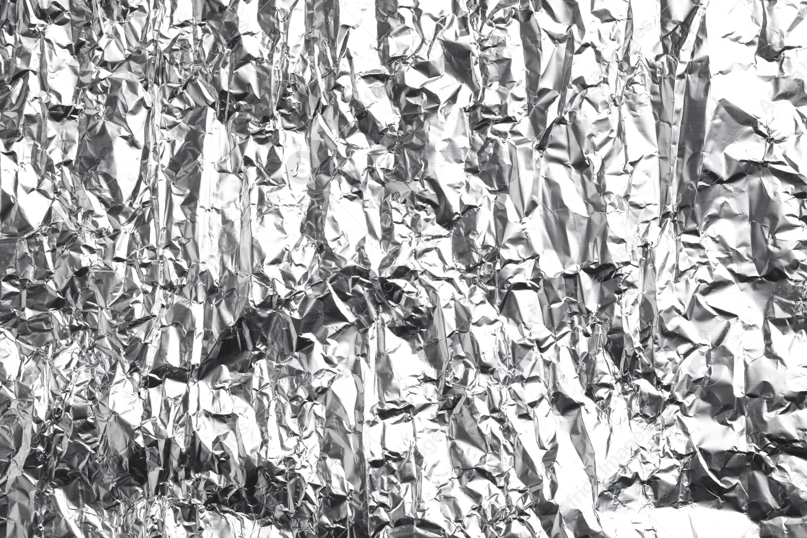 Photo of Crumpled silver foil as background, closeup view