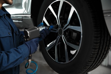 Technician working with car using in automobile repair shop, closeup