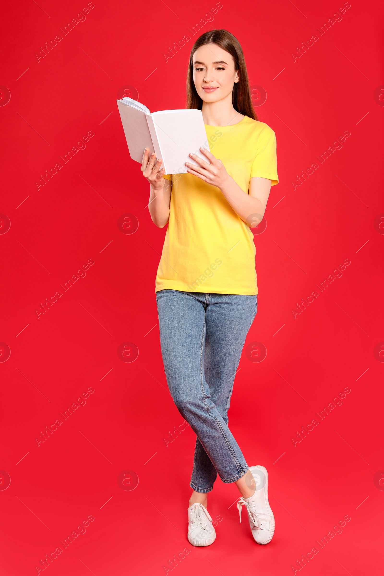 Photo of Young woman reading book on color background