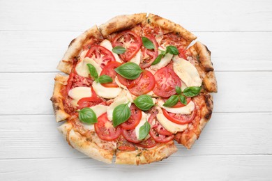 Photo of Delicious Caprese pizza on white wooden table, top view