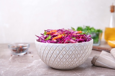 Bowl with chopped red cabbage on table