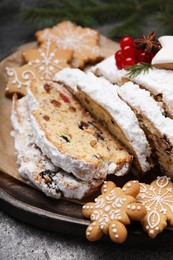 Photo of Traditional Christmas Stollen with icing sugar on grey table, closeup
