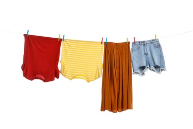 Different clothes drying on laundry line against white background