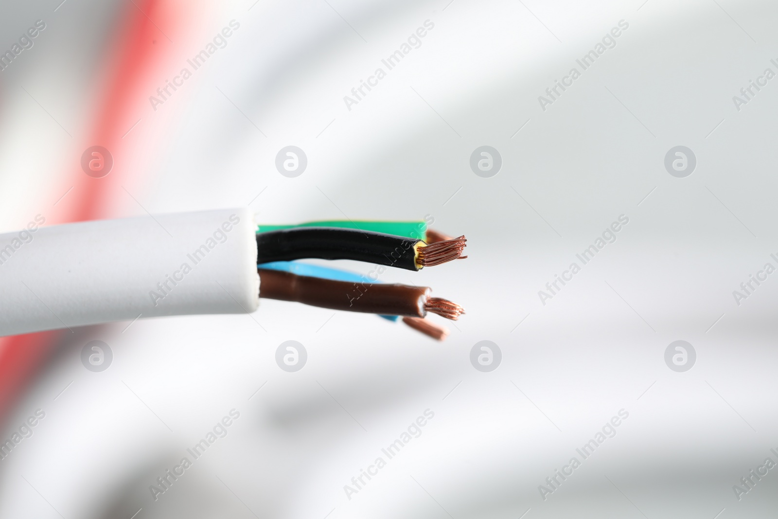 Photo of Colorful electrical wire on blurred background, closeup. Space for text