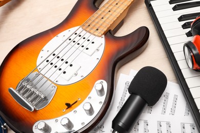 Photo of Different musical instruments, headphones and microphone on wooden background, closeup
