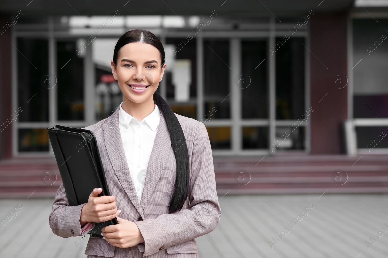 Photo of Beautiful real estate agent with documents outdoors, space for text