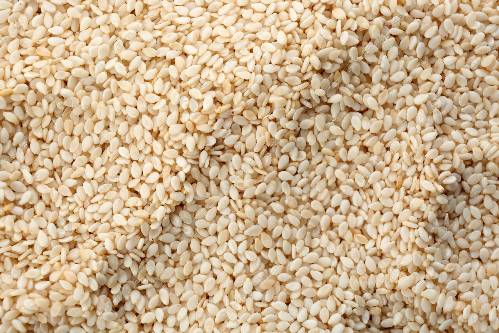 Photo of Pile of white sesame seeds as background, top view