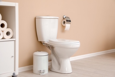 Photo of Holder with toilet paper roll on wall in bathroom