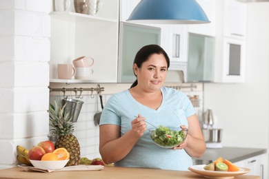 Photo of Woman with bowl of vegetable salad in kitchen. Healthy diet