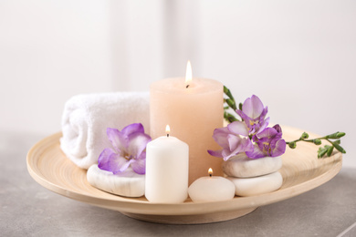 Photo of Beautiful composition with spa stones and burning candles on grey table