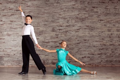 Photo of Beautifully dressed couple of kids dancing together in studio, space for text