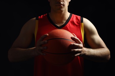 Basketball player with ball on black background, closeup