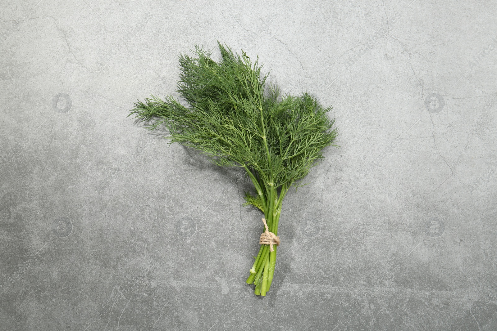 Photo of Bunch of fresh dill on light grey table, top view