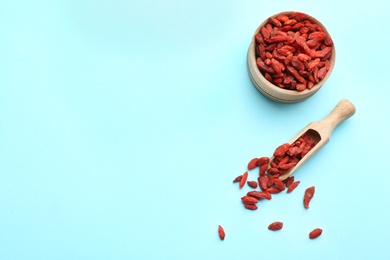 Photo of Flat lay composition with dried goji berries on light blue background, space for text. Healthy superfood