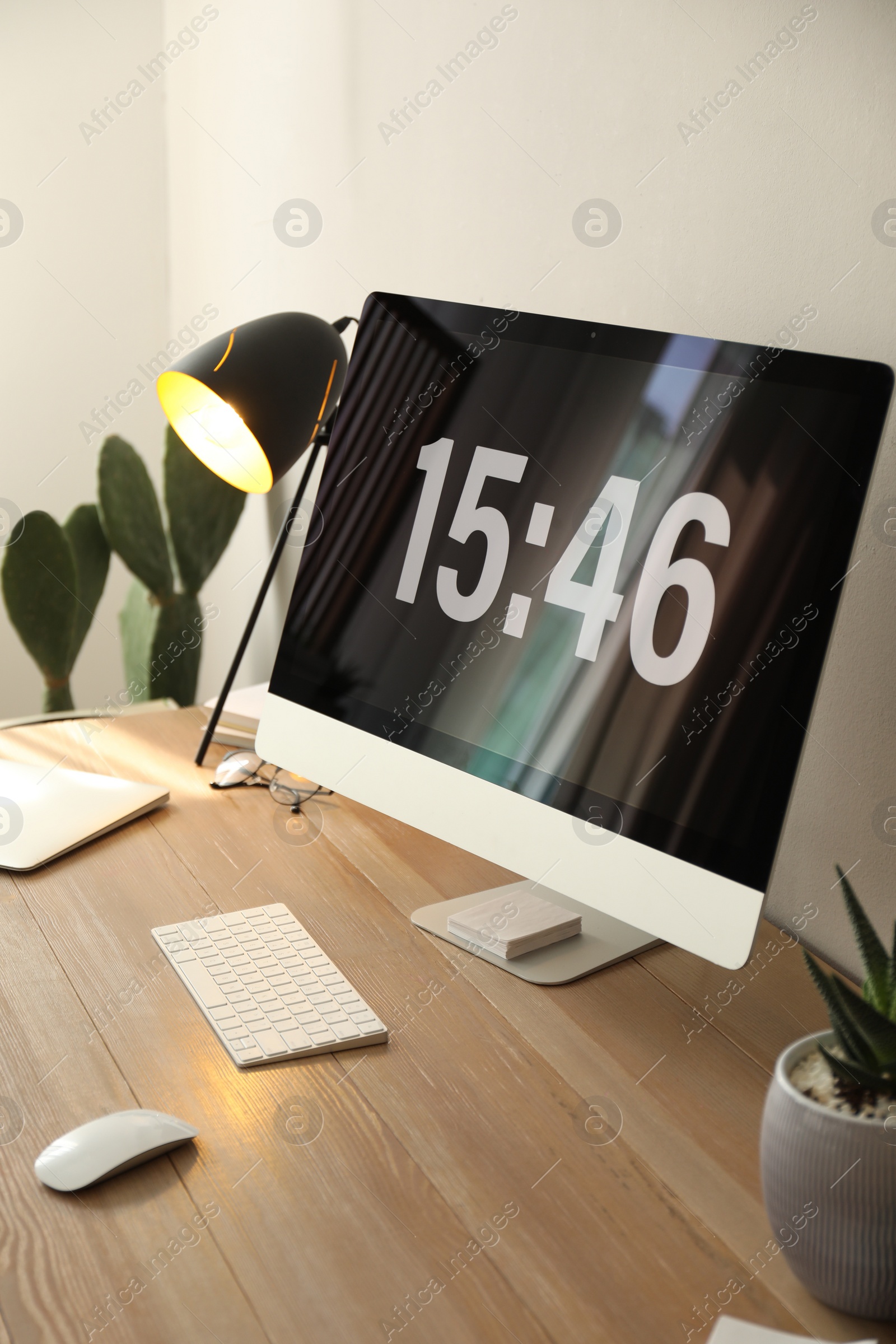 Photo of Modern computer and laptop on wooden desk in room. Interior design