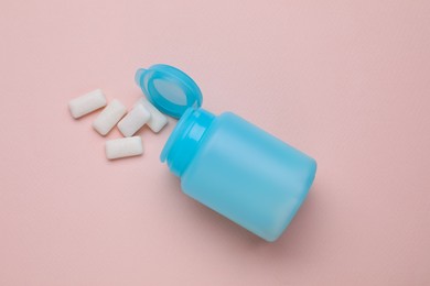 Photo of Jar with chewing gums on light pink background, flat lay