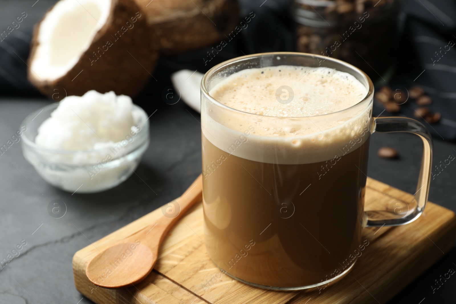 Photo of Delicious coffee with organic coconut oil on grey table