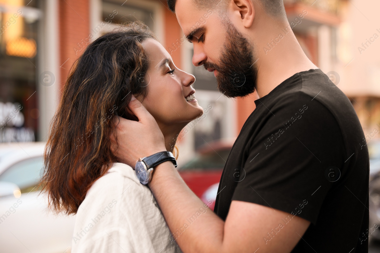 Photo of Happy young couple kissing on city street