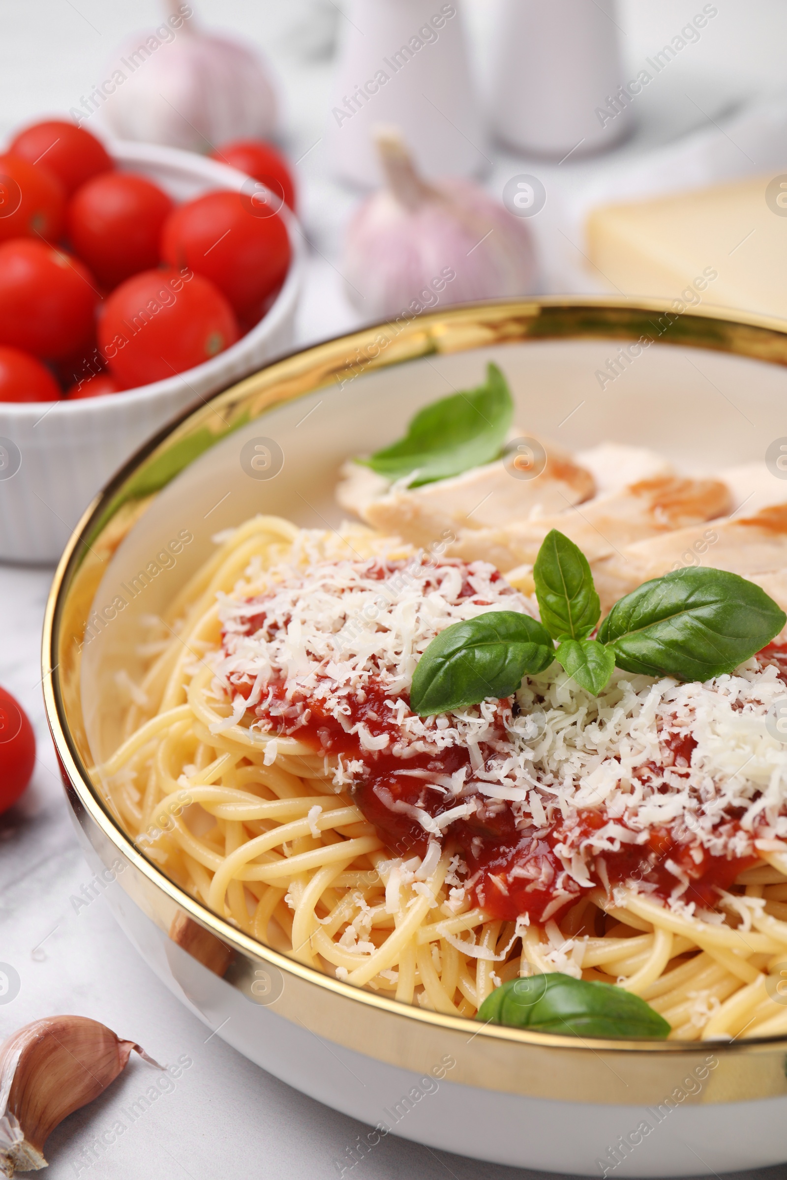 Photo of Delicious pasta with tomato sauce, chicken and parmesan cheese on white table, closeup