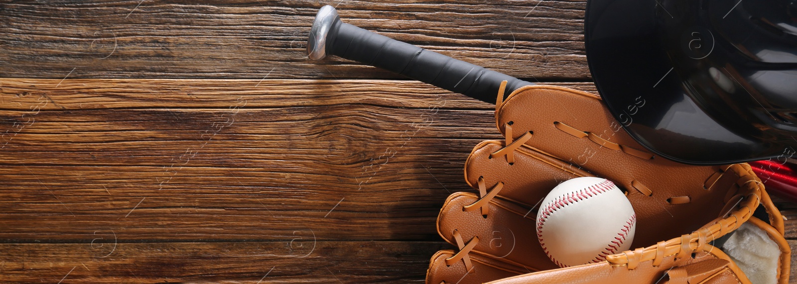 Image of Baseball glove, bat, ball and batting helmet on wooden table, flat lay. Banner design with space for text