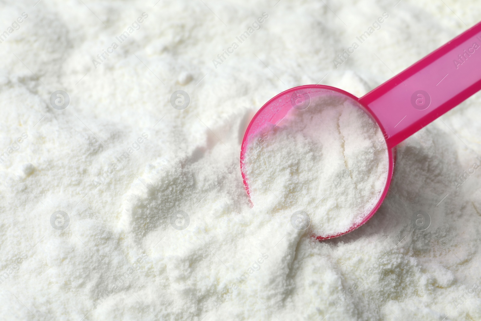 Photo of Powdered infant formula and scoop, closeup with space for text. Baby milk