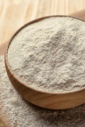 Photo of Quinoa flour in bowl on wooden table, closeup