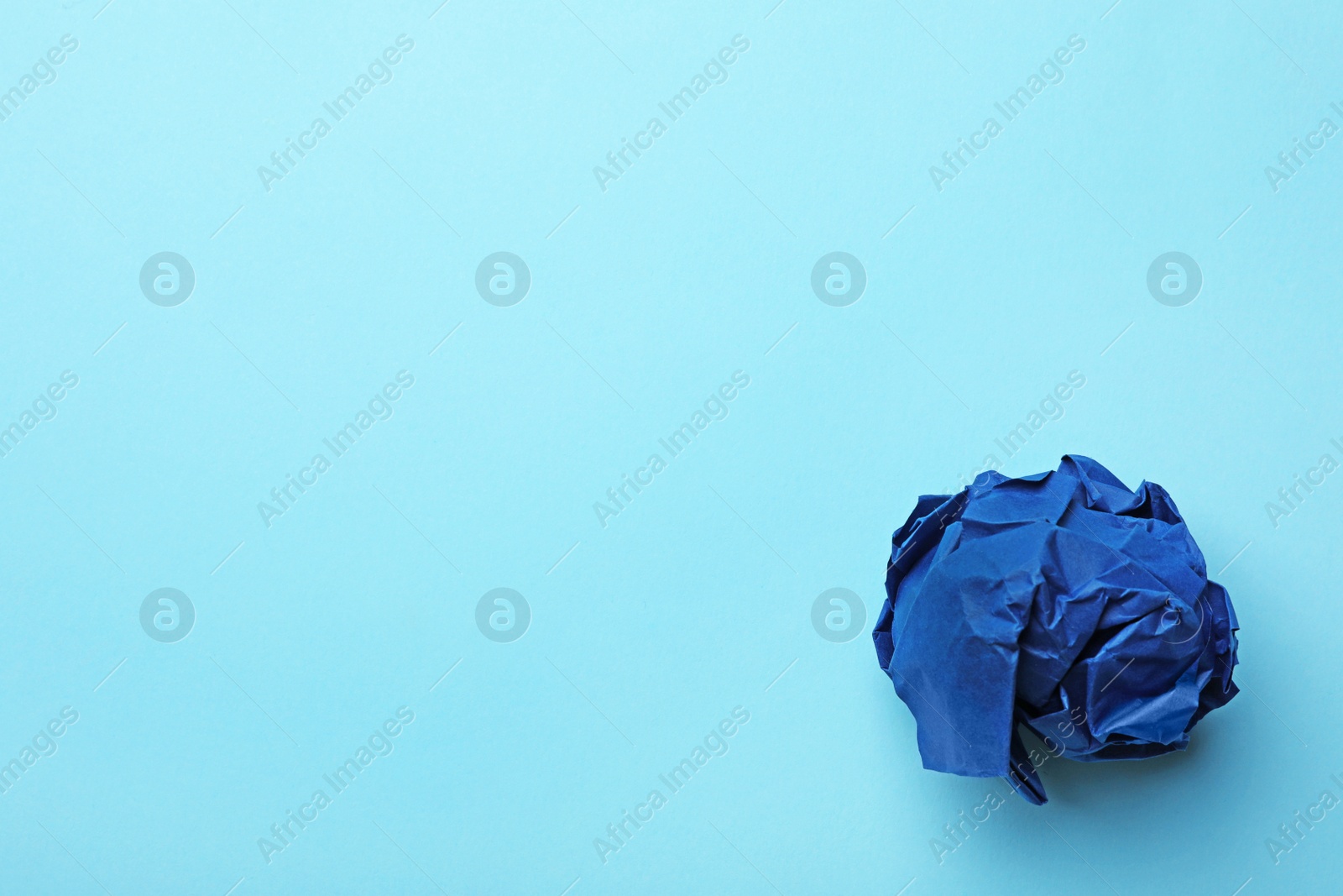 Photo of Crumpled sheet of paper on color background, top view. Space for text