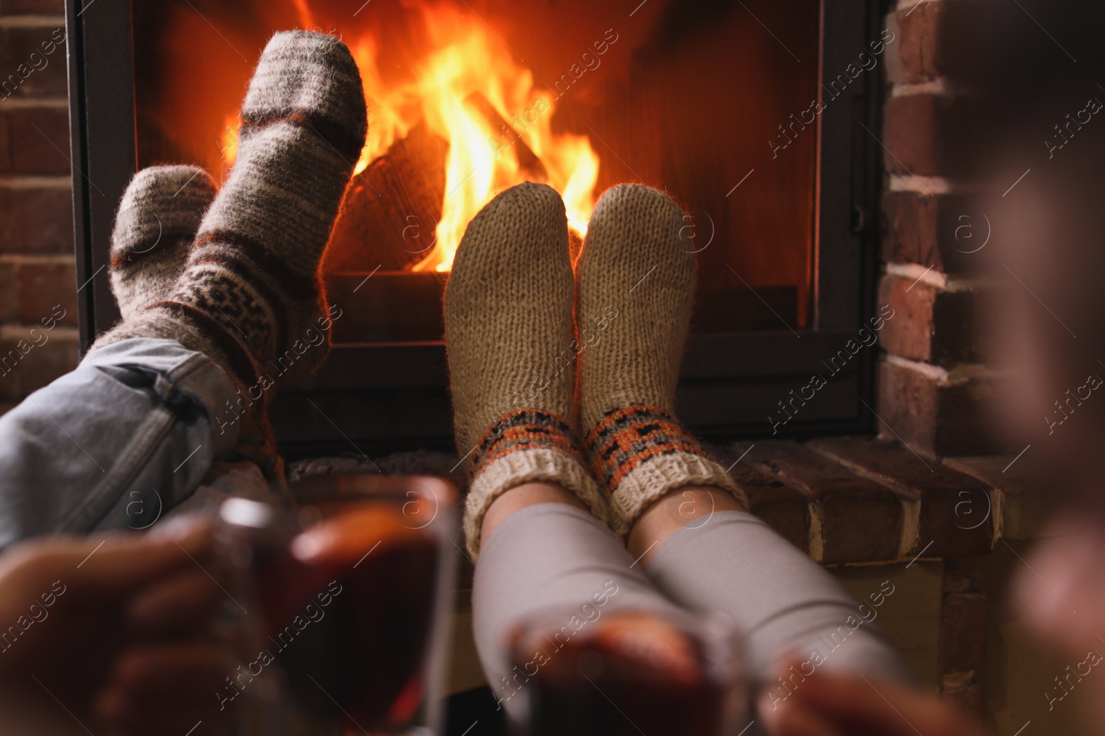 Photo of Couple resting near fireplace indoors, closeup. Winter vacation