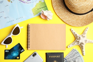 Photo of Flat lay composition with tourist items and notebook on color background, space for text. Travel agency